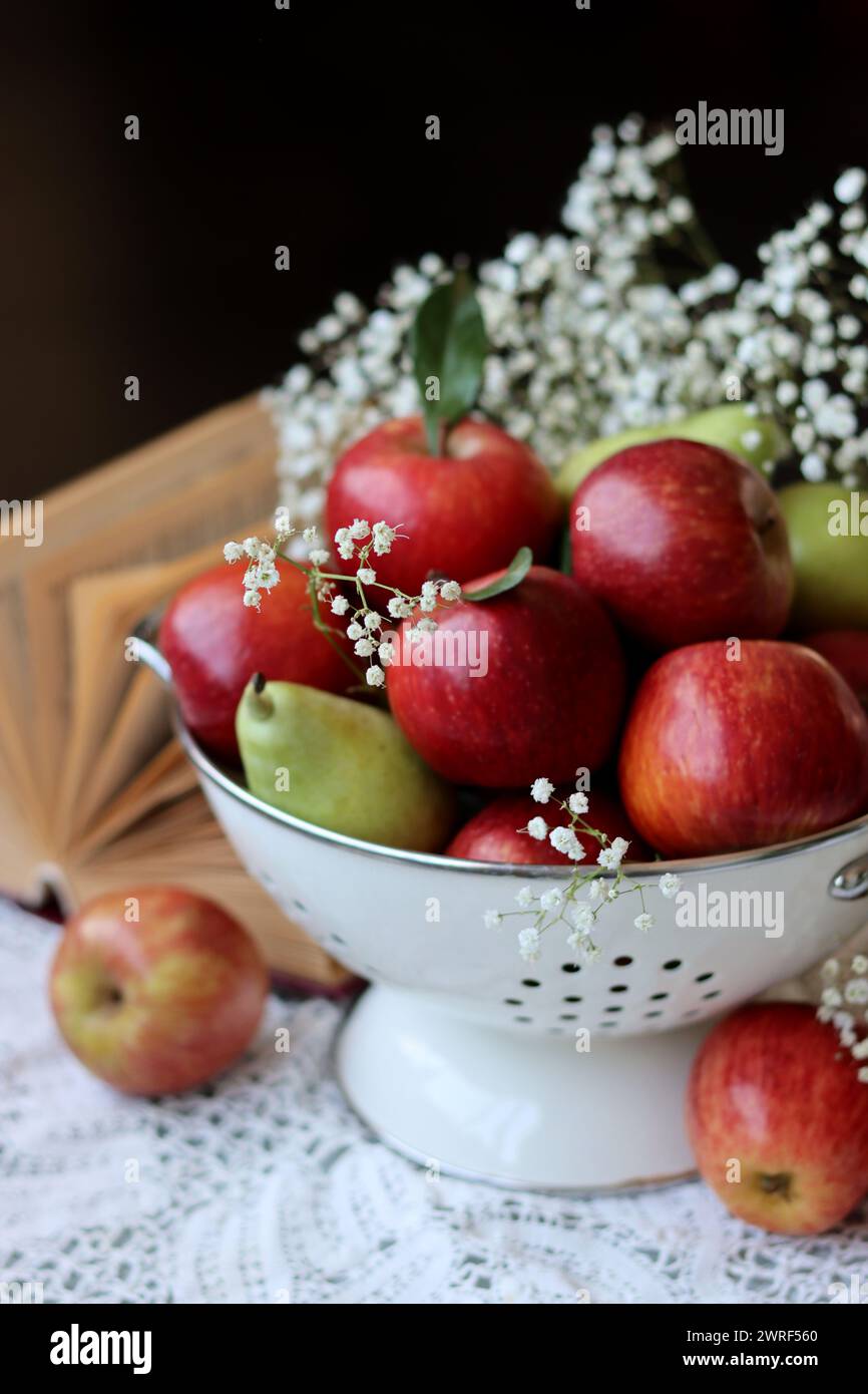 Stillleben Foto mit roten Äpfeln und weißen Blumen. Harvest Festival Konzept. Frisches Obst aus der Farm aus nächster Nähe. Stockfoto