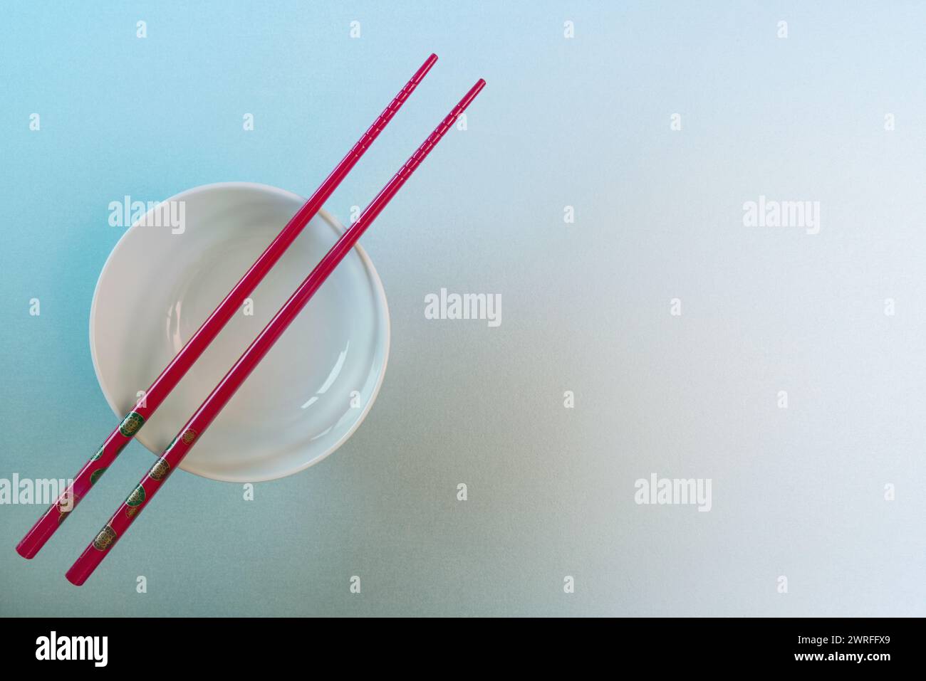 Eine weiße Keramikschale mit roten Essstäbchen im japanischen Stil Stockfoto