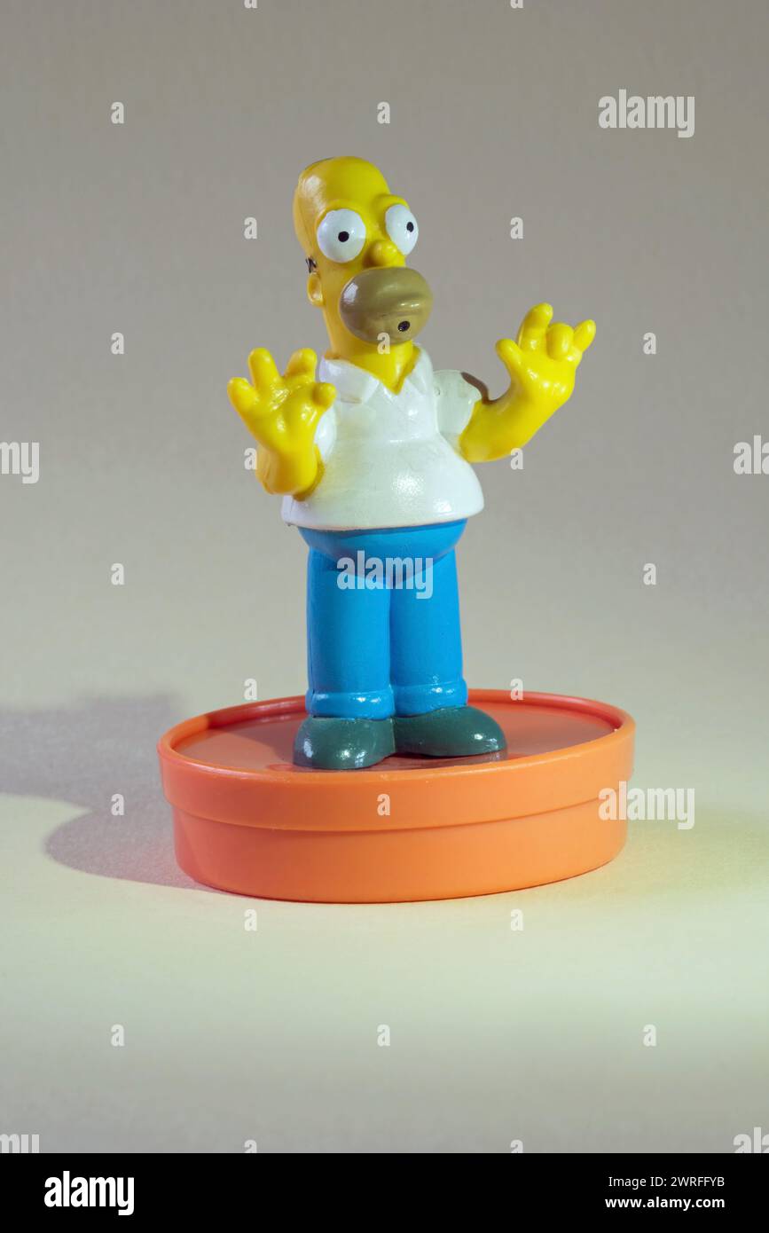 Homer Simpson-Figur aus Kunststoff auf orangefarbenem Sockel Stockfoto