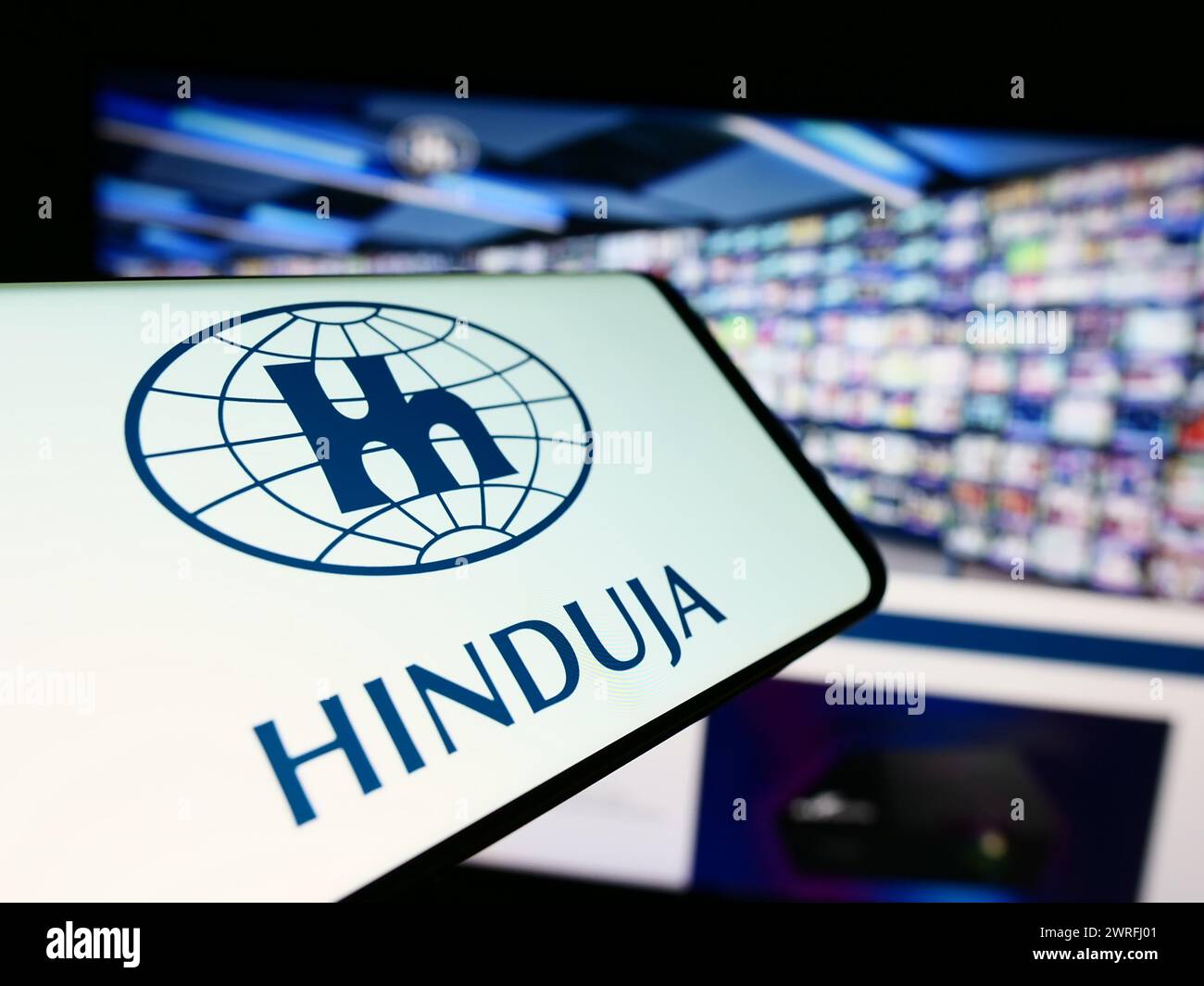 Smartphone mit Logo des indischen Konzerns Hinduja Group Ltd. Vor der Business-Website. Konzentrieren Sie sich auf die Mitte des Telefondisplays. Stockfoto