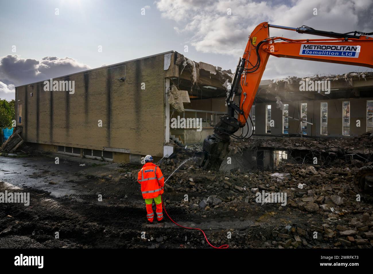 Abbruchstelle (Mann in gut sichtbarem Arbeitsschutt, Baurückbau, kontrollierter Zusammenbruch, leere Hülle) - Baildon, West Yorkshire England Großbritannien. Stockfoto