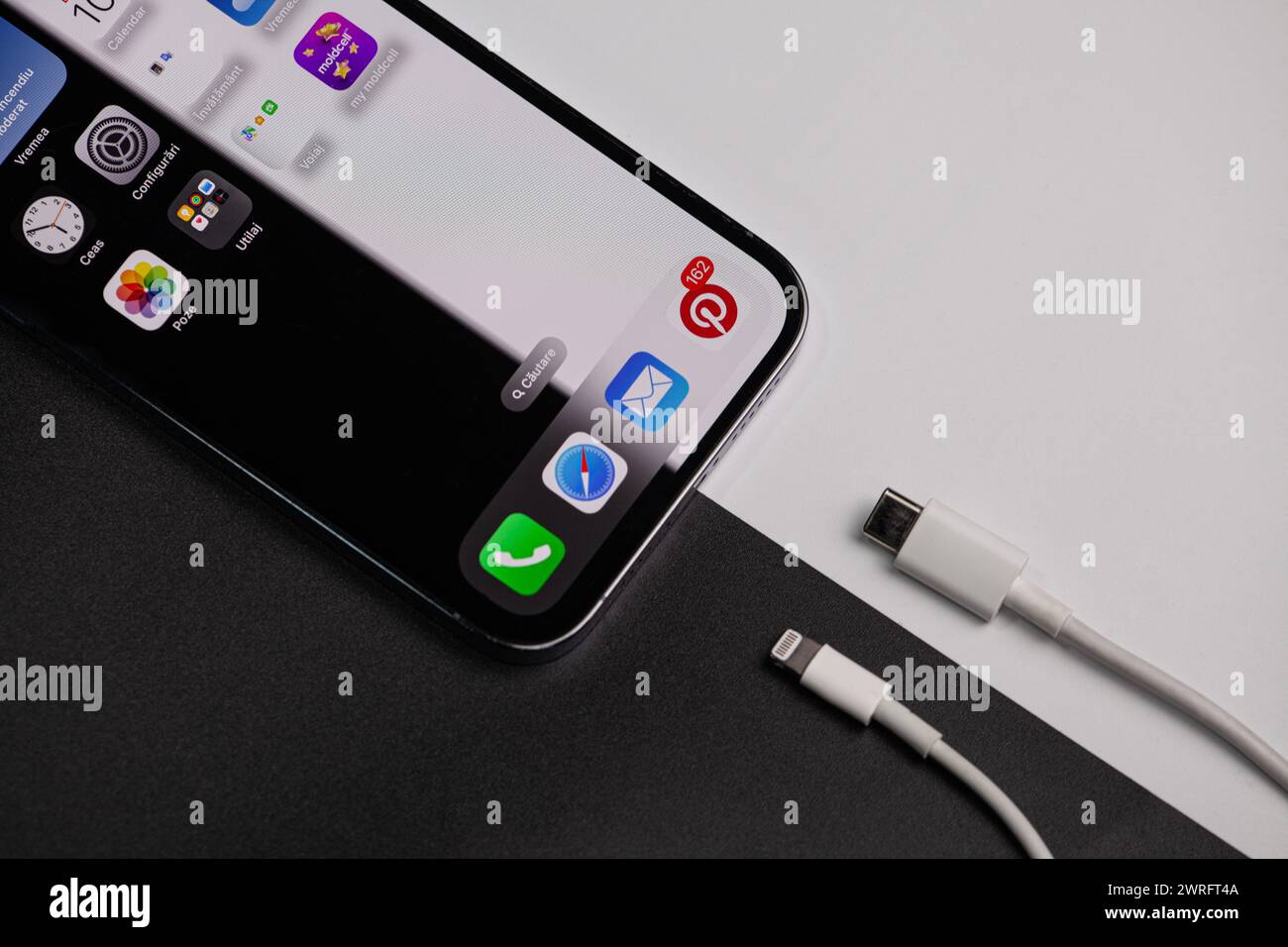 IPhone, das als Hintergrund ein Schwarzweißbild hat, das zeigt, dass auf der schwarzen Farbe das alte Ladegerät und auf dem weißen das neue Typ c ist Stockfoto