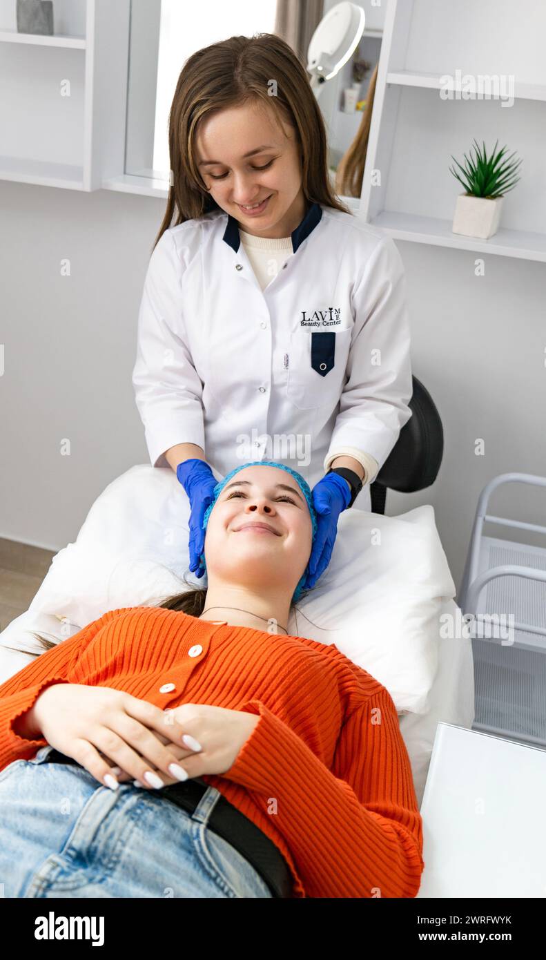 Der Kosmetiker kosmetologe bereitet den Kunden auf die Behandlung oder Gesichtsbehandlungen in einem Salon vor. Hardware-Kosmetologie im klinischen Salon für Th Stockfoto