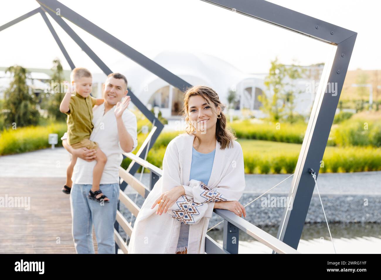 Zwei Leute, ein Mann und eine Frau, die in der Mitte einer Brücke stehen und auf die Aussicht blicken. Die Brücke besteht aus Stahl und überblickt einen Fluss darunter. Stockfoto