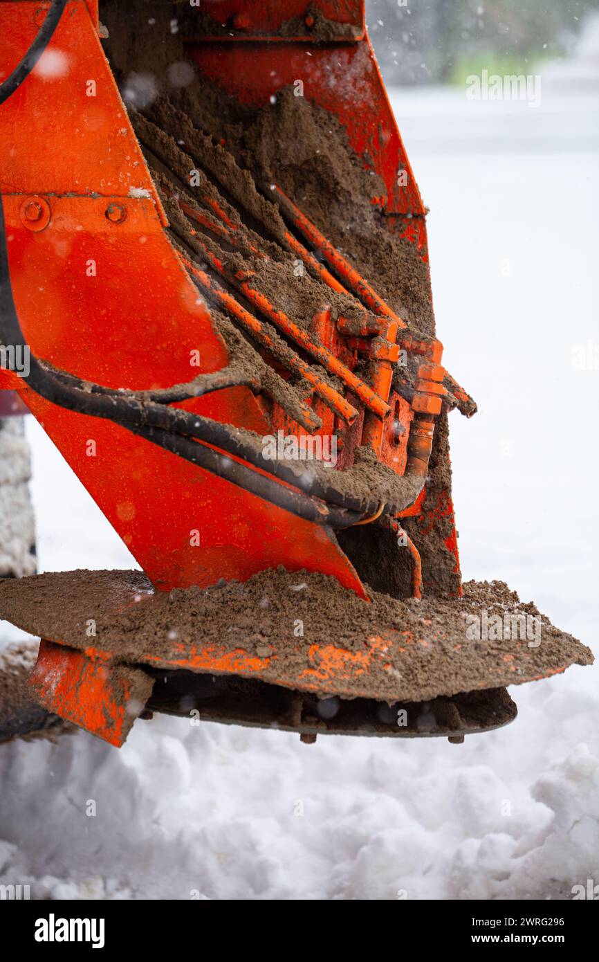 Salzen von Autobahnwartungen. Schneepflug-Lkw auf verschneiten Straßen in Aktion. Harte Wetterbedingungen im Winter. Das Fahrzeug verteilt Enteisungssalz. Hohe Qualität p Stockfoto