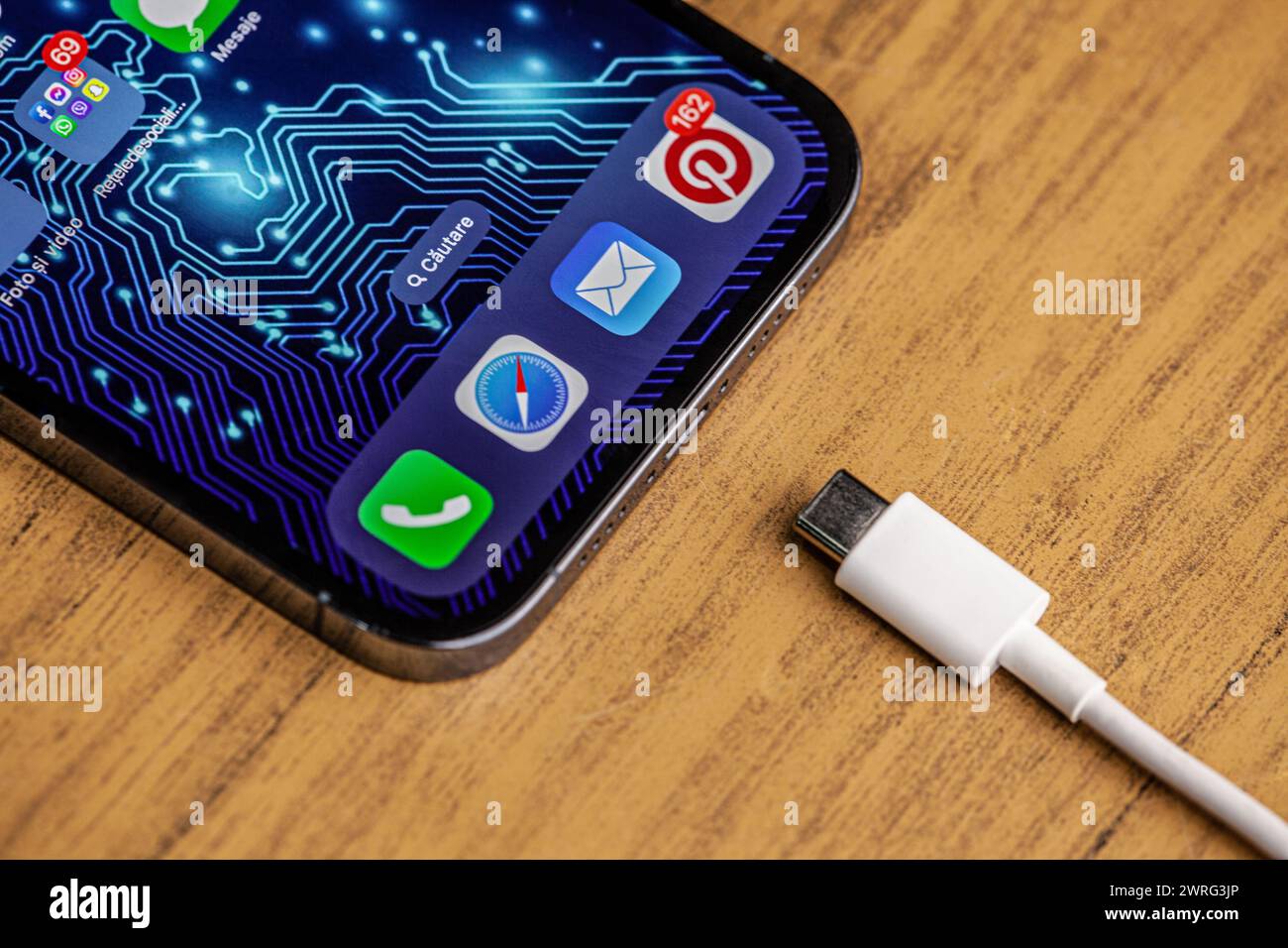 Ein Bild des neuen iPhone 15 mit dem neuen Ladegerät auf hölzernem Hintergrund und Hintergrund der künstlichen Intelligenz.Hincesti, Moldawien, 11,09 Stockfoto