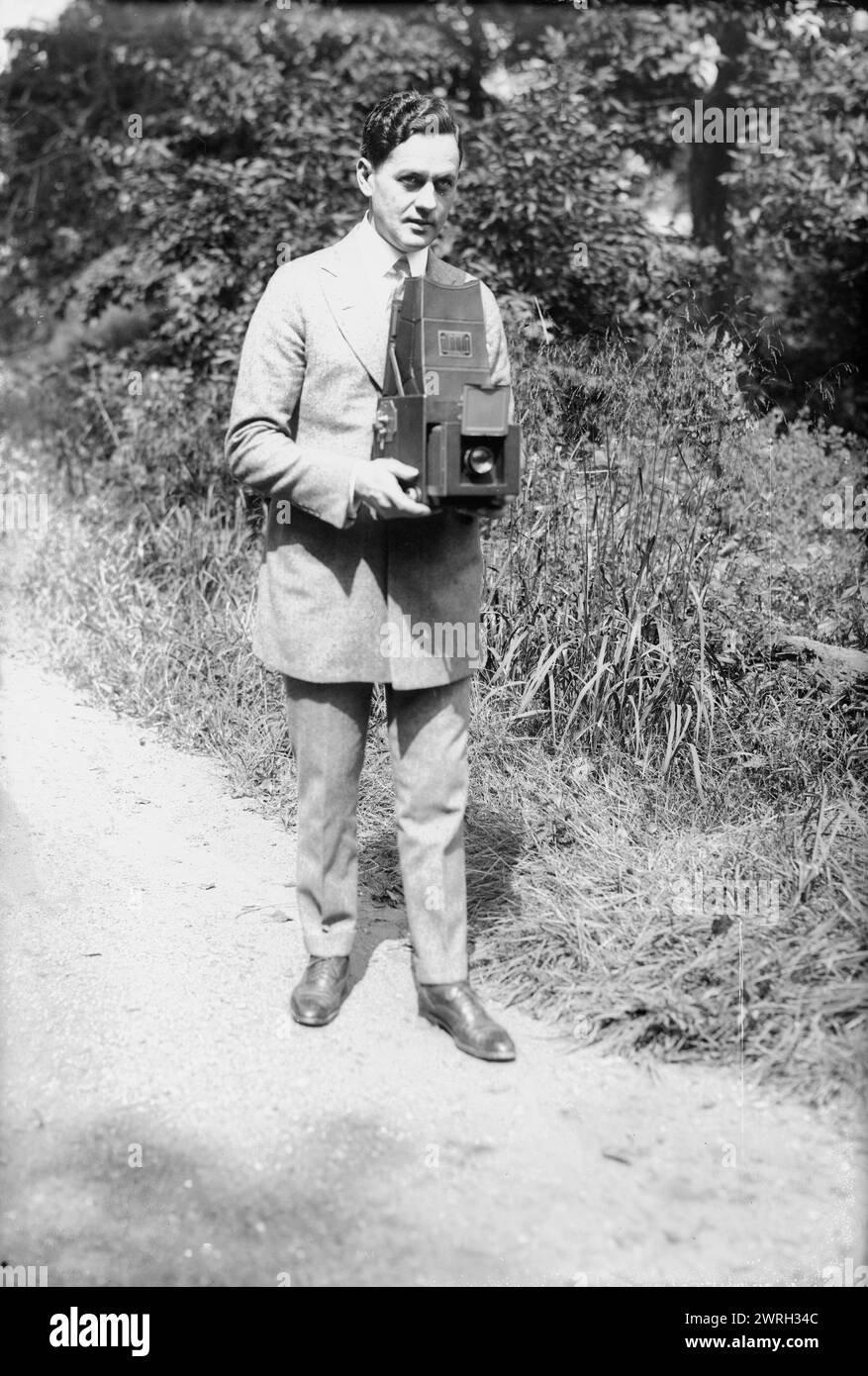 Asche, zwischen 1915 und 1920. Zeigt den Schauspieler Sam Ash (1884–1951), der auch in Varieté und Film auftrat. Ash hält eine Kamera. Stockfoto