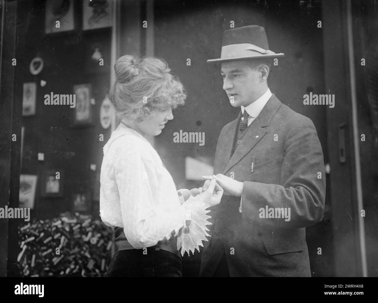 Henrietta Mielke schenkt eisernen Ring an Beitragende, 22. Oktober 1914 (Erstellungsdatum oder Veröffentlichung später). Henrietta Mielke (* 1897) gibt einem Mann einen Ring. Ihr Vater, Henry Mielke, war Ladenbesitzer und Mitglied der Organisation „Gold for Iron“ (Gold fur Eisen), die im Austausch gegen Gold und Juwelen, die zur Unterstützung der deutschen Kriegsanstrengungen während des Ersten Weltkriegs verwendet wurden, Eisenringe an Menschen gab Das Foto wurde wahrscheinlich draußen aufgenommen? Mielke's Geschäft befindet sich an der Second Avenue an der Ecke 87th Street in New York City. Stockfoto