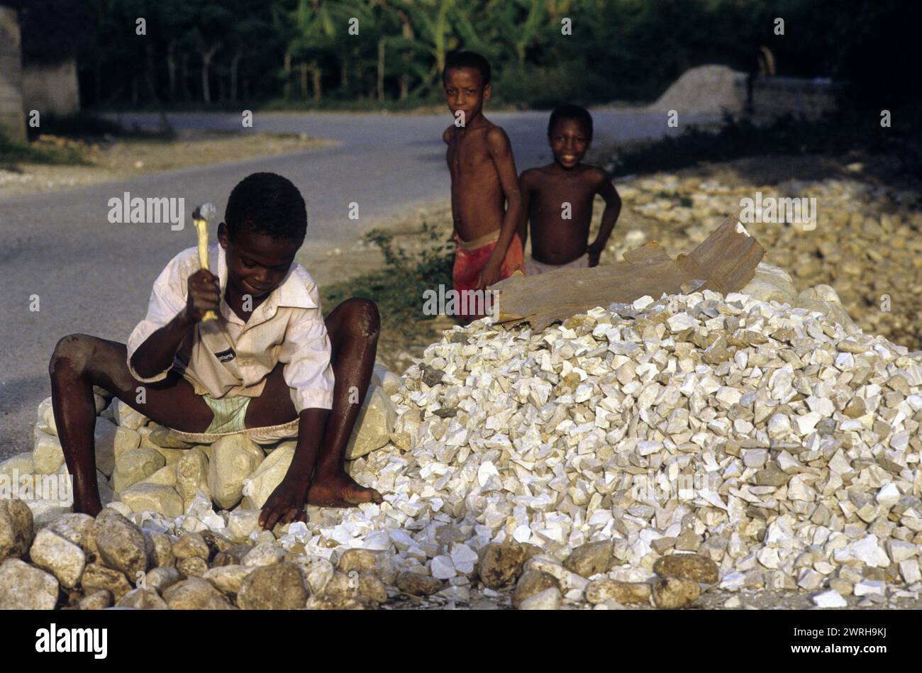 18. Mai 1994; Port-au-Prince, Haiti-Ein Kind zerquetscht Steine für den Bau. Kinder in Haiti werden oft in der Arbeitswelt der Ärmsten eingesetzt Stockfoto