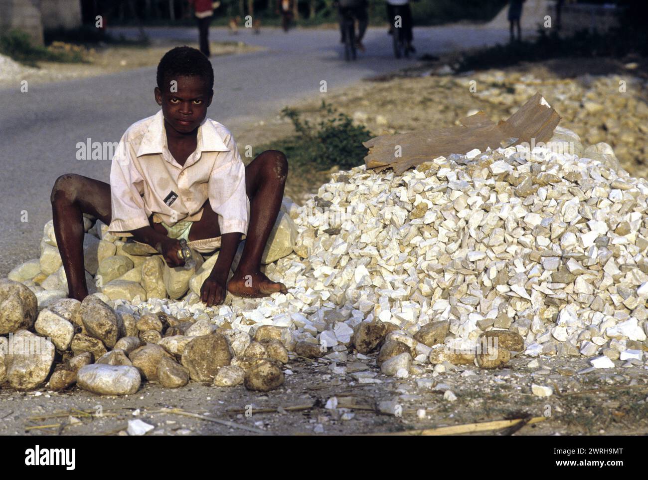 18. Mai 1994; Port-au-Prince, Haiti-Ein Kind zerquetscht Steine für den Bau. Kinder in Haiti werden oft in der Arbeitswelt der Ärmsten eingesetzt Stockfoto