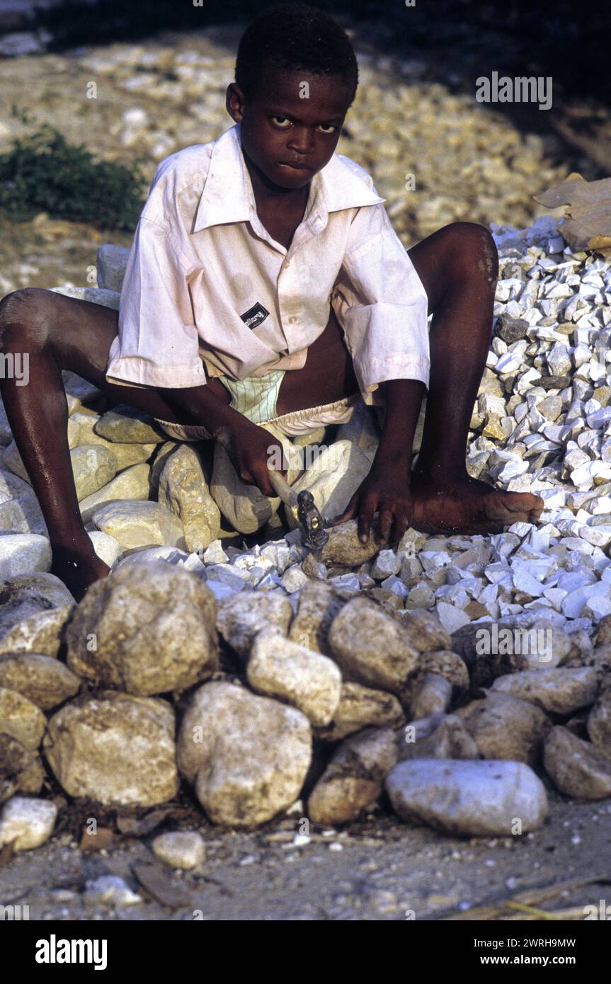 18. Mai 1994; Port-au-Prince, Haiti-Ein Kind zerquetscht Steine für den Bau. Kinder in Haiti werden oft in der Arbeitswelt der Ärmsten eingesetzt Stockfoto