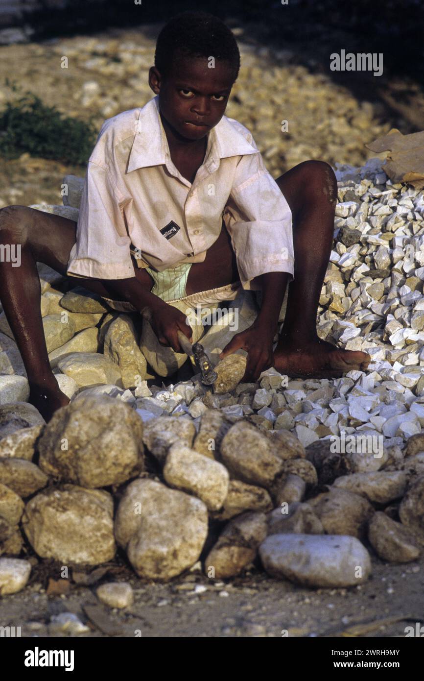 18. Mai 1994; Port-au-Prince, Haiti-Ein Kind zerquetscht Steine für den Bau. Kinder in Haiti werden oft in der Arbeitswelt der Ärmsten eingesetzt Stockfoto