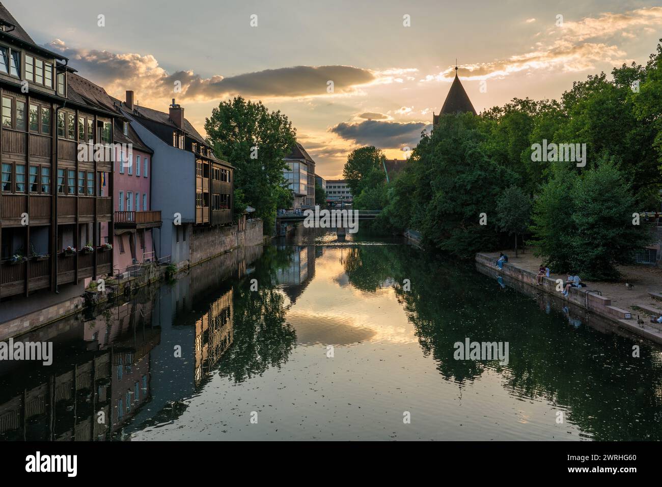 Dies ist ein Blick auf den Sonnenuntergang der Pegnitz mit traditionellen deutschen Gebäuden am Flussufer am 15. August 2022 in Nürnberg Stockfoto