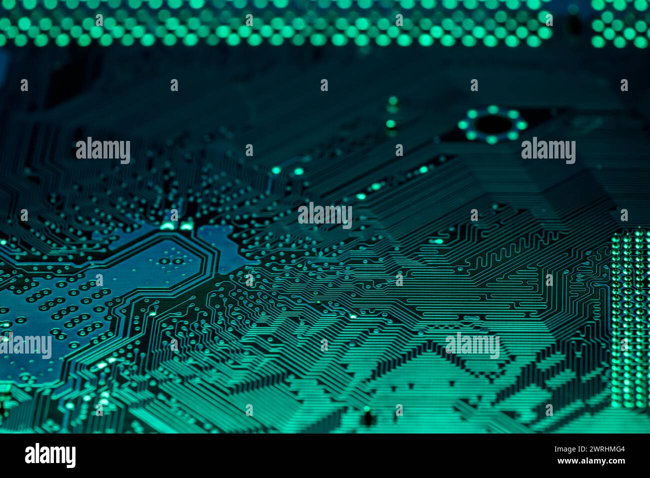 Grünes PC-Mainboard. Extreme Nahaufnahme elektrischer Verbindungen. Stockfoto