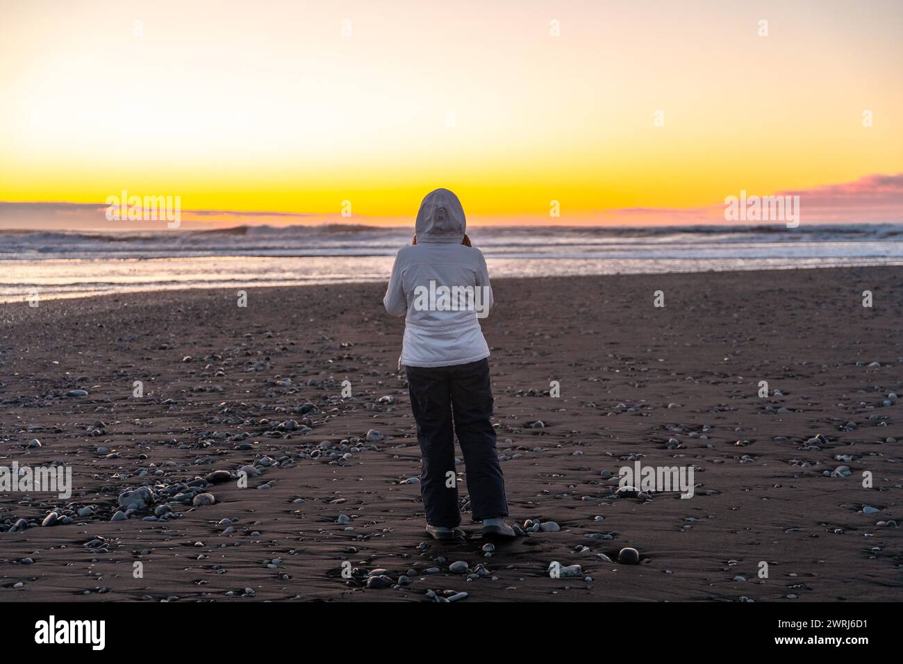 Frau bei Sonnenaufgang am Diamond Beach im Urlaub in Island Stockfoto