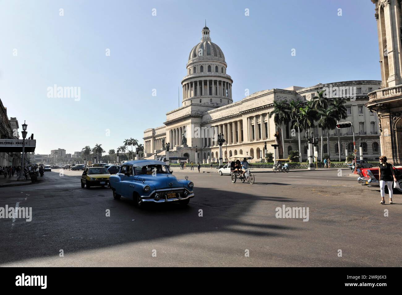 Eine geschäftige Straße vor dem Kapitol mit Oldtimern und klassischer Architektur bei Tageslicht, Havanna, Kuba, Zentralamerika Stockfoto