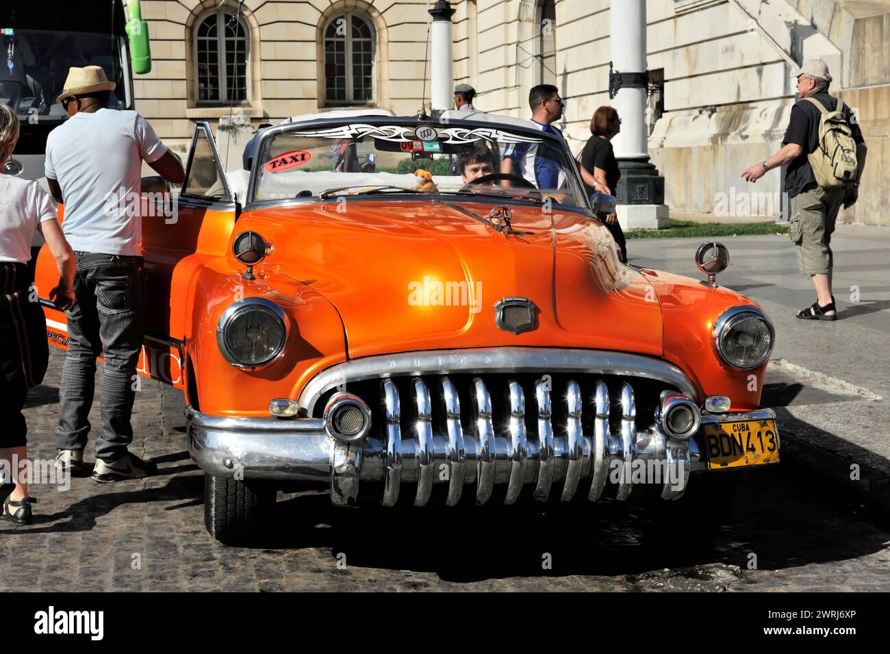 Orangene Taxis halten an einer belebten Straße in Havanna, Kuba, Mittelamerika Stockfoto