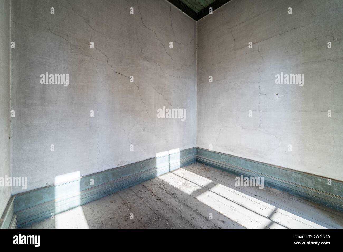 Altes, leeres Zimmer aus verlassenem Haus ohne Möbel. Licht aus den Fenstern. Hintergrund mit Kopierraum Stockfoto