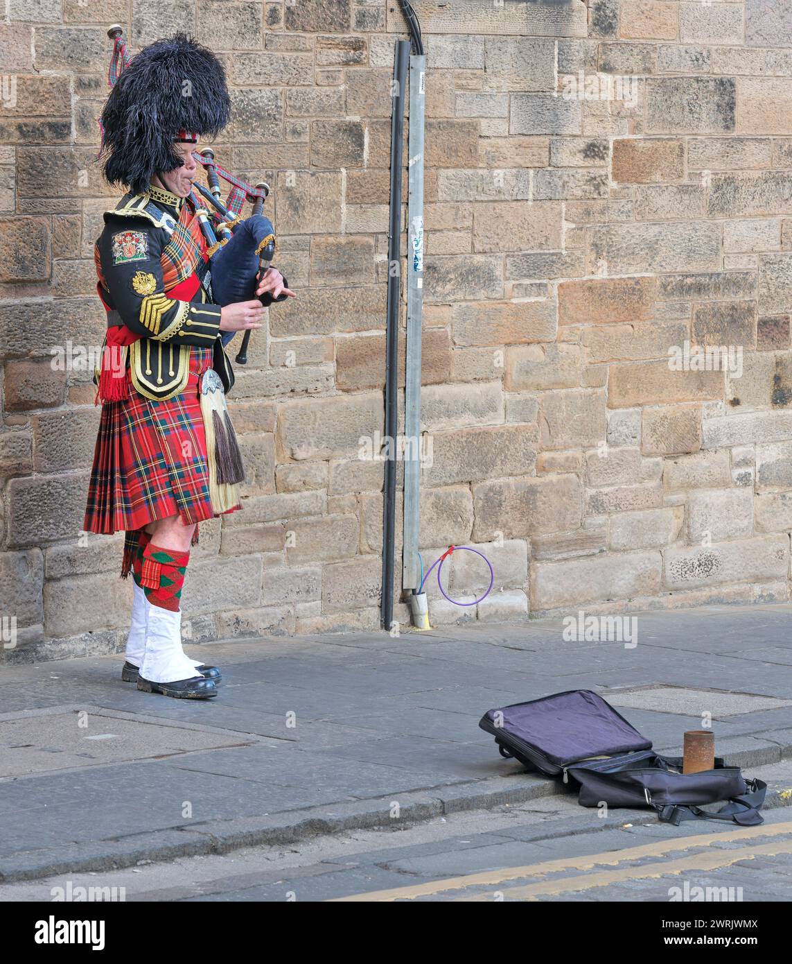 Ein einsamer Piper in schottischen Militäruniform Busks auf Castlehill, Royal Mile, Edinburgh, Schottland. Stockfoto
