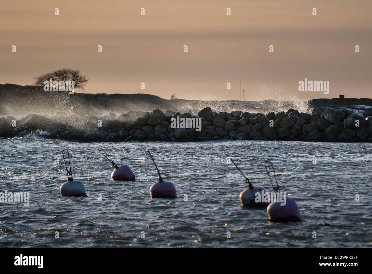 IM JURMO HAUPTHAFEN, OSTSEE, STÜRZEN WELLEN ÜBER Eine WELLENBRECHER: Im Haupthafen der Fähre auf Jurmo, einer kleinen Insel im Turku-Archipel, vor der Südwestküste Finnlands, schweben winterliche Sturmwellen. Foto: Rob Watkins. INFO: Jurmo hat eine Bevölkerung von etwa 50 Einwohnern und ist bekannt für sein raues Gelände, seine malerische Landschaft und seine einzigartige Flora und Fauna. Jurmo ist der letzte oberirdische Teil des eiszeitlichen geologischen Salpausselkä-Gebirgssystems, das Finnland durchquert. Stockfoto