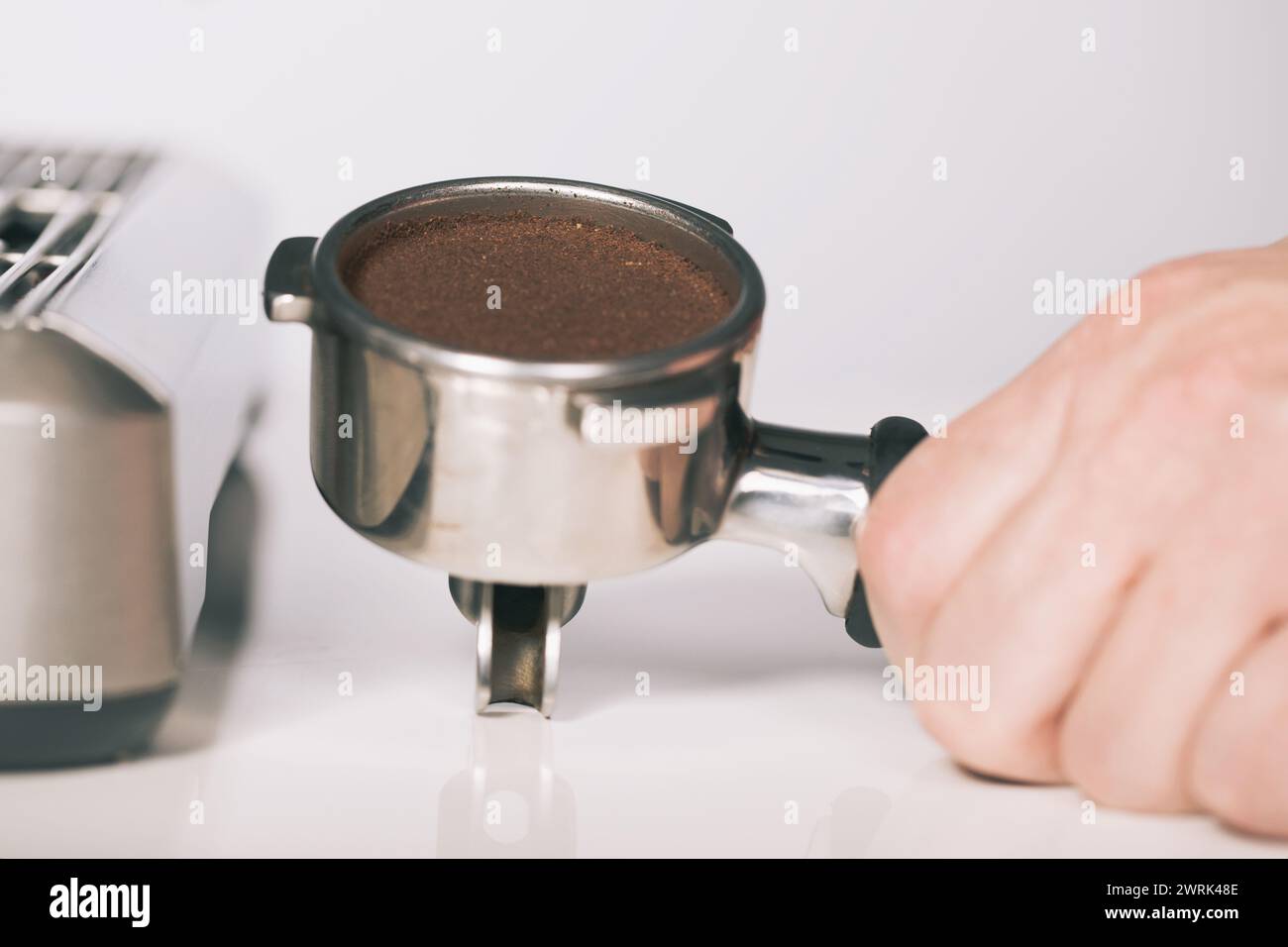 Drücken des gemahlenen Kaffees in den Griff zum Herausziehen in der Espressomaschine Stockfoto