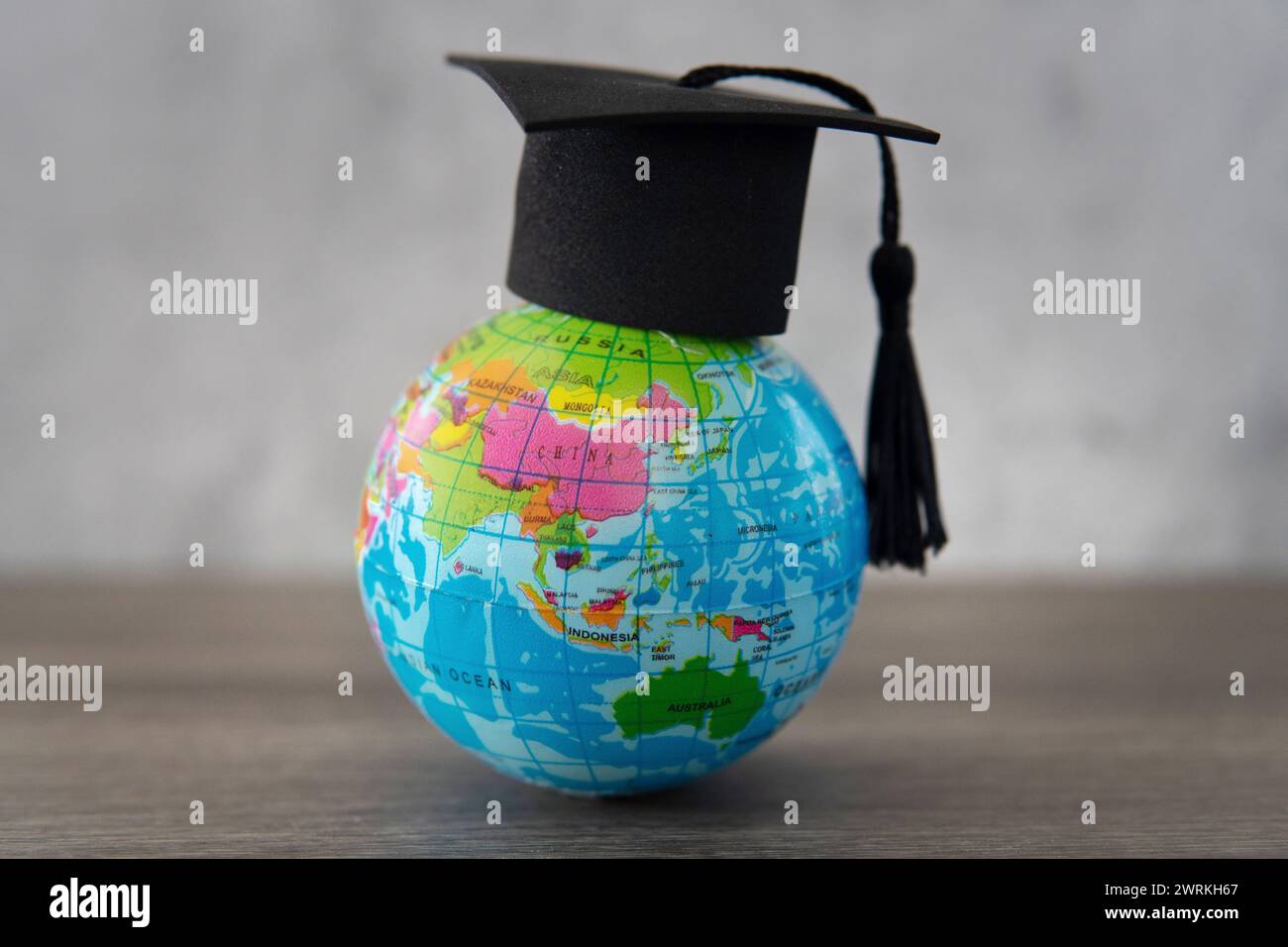 Graduierungskappe auf der Weltkugel mit Kopierraum. Im Ausland studieren. Das Konzept ausländischer Studenten. Stockfoto