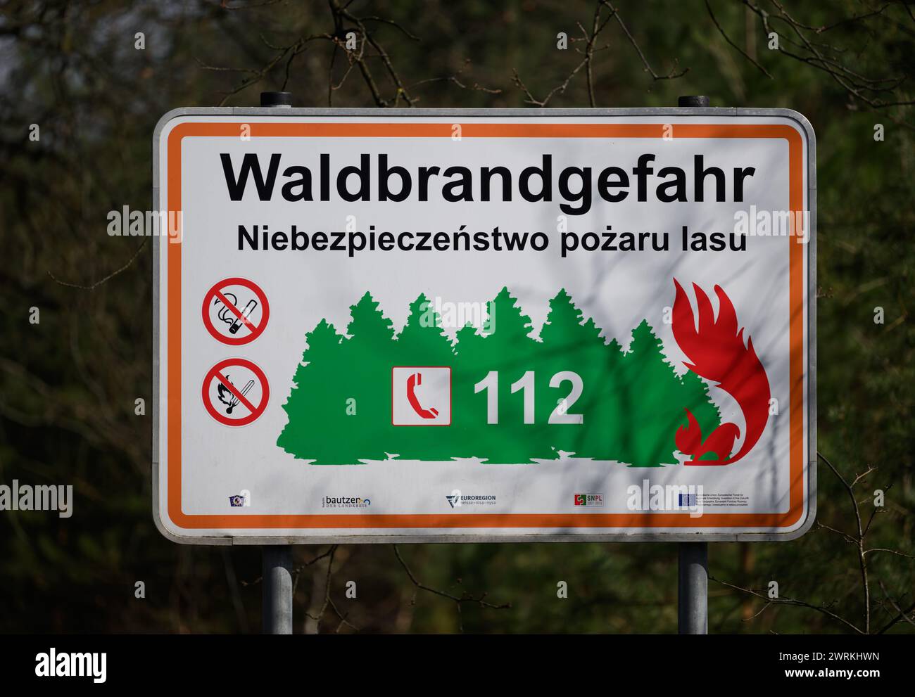 Hoyerswerda, Deutschland. März 2024. Auf einer Straße in der Nähe des Waldes befindet sich ein Schild mit dem Hinweis „Waldbrandgefahr“. Ein Bericht über das System wurde in der Hauptfeuerwehr im Rahmen einer Presseveranstaltung zur Erinnerung an „20 Jahre automatisches Waldbrand-Frühwarnsystem“ (AWFS) vorgelegt. Die Leitstelle führt eine gemeinsame Überwachung mit der Feuerwehr für die Bezirke Görlitz, Bautzen, Meißen und Nordsachsen durch. Robert Michael/dpa/Alamy Live News Stockfoto