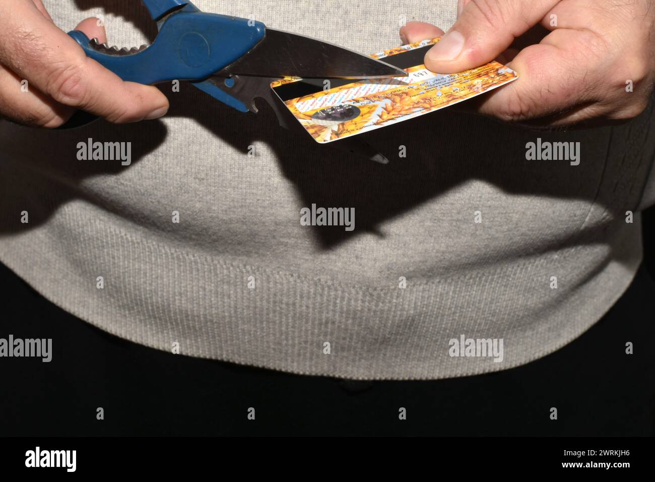 Auf dem Nahbild zerstören Männerhände eine Plastikkarte. Stockfoto