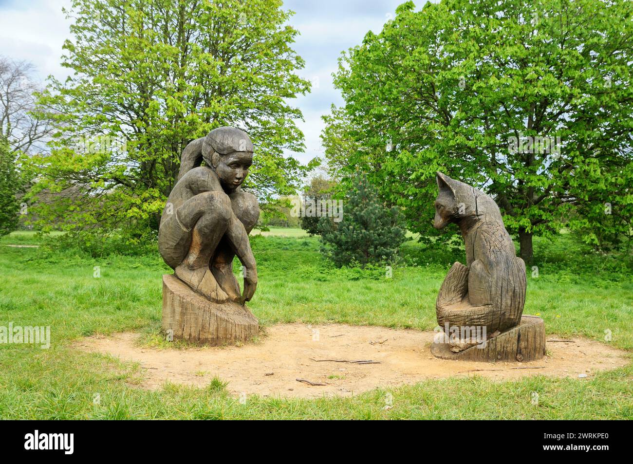 Mädchen und Fuchs Holzskulpturen aus Holz des Künstlers Tom Harvey, Regent's Park, London, England, Großbritannien. Holzskulptur öffentliche Kunstwerke Statuen Stockfoto