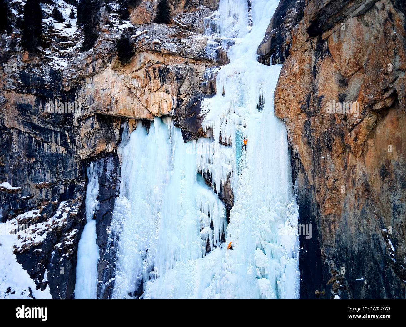 Blick auf die Drohne von Athleten Eisklettern großer gefrorener Wasserfall in der Barskoon-Schlucht im Bergtal im südlichen Teil des Issyk Kul-Sees in Kirgisistan Stockfoto