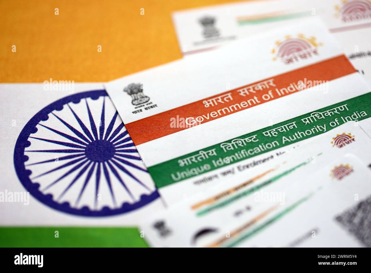 Indische Aadhaar-Karte von der Unique Identification Authority of India auf indischer Flagge Nahaufnahme Stockfoto