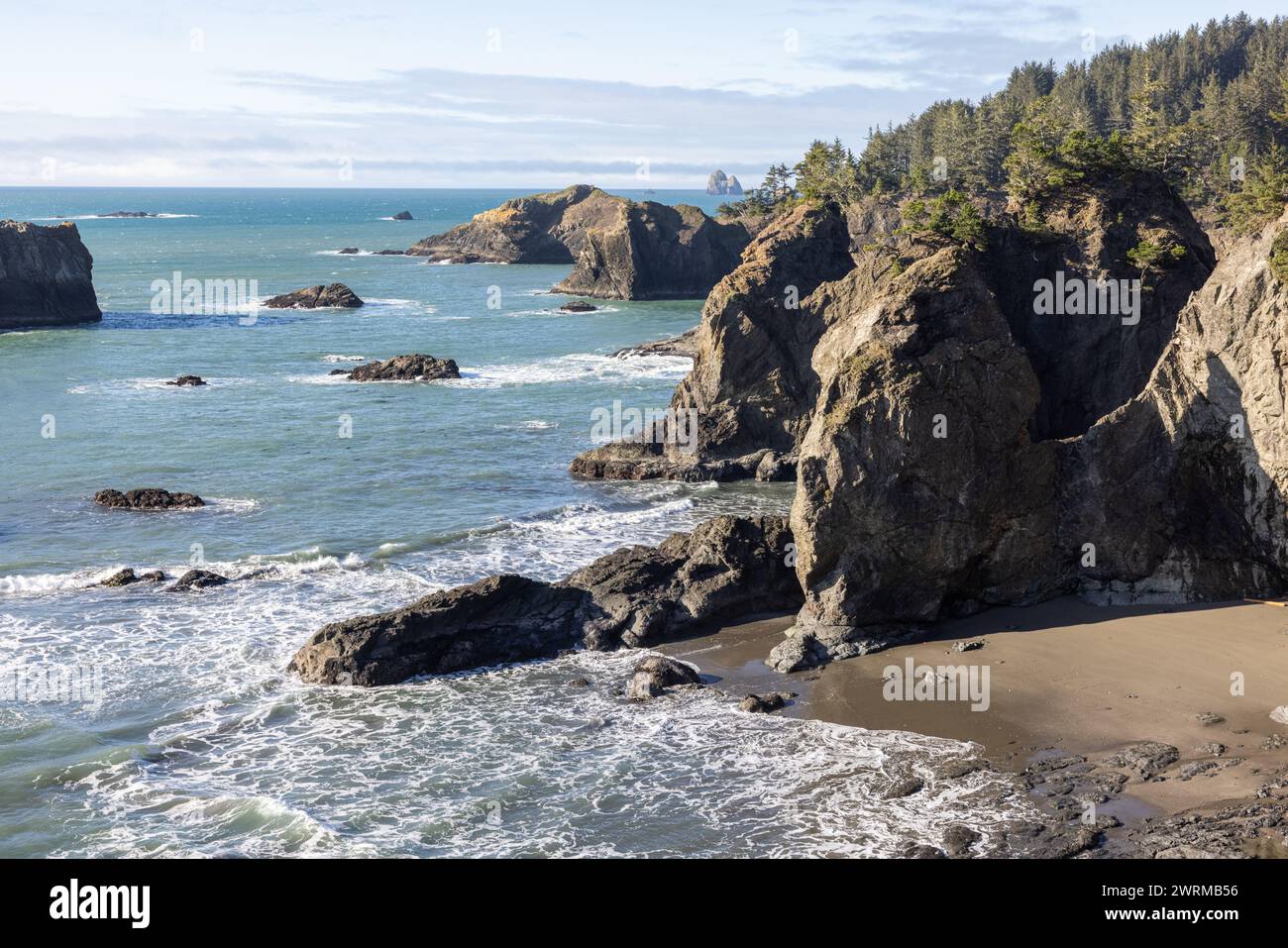 Das Meer ist ruhig und die Felsen sind zerklüftet. Der Strand ist felsig und das Wasser ist blau Stockfoto