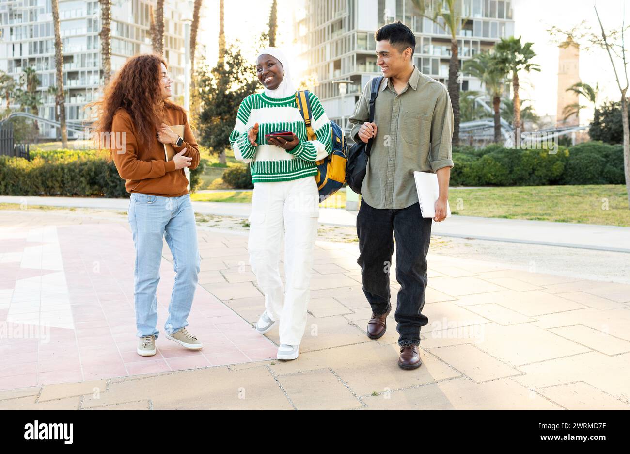 Eine multiethnische Gruppe junger Erwachsener, darunter eine afroamerikanische Frau, ein hispanischer Mann und eine Frau mit lockigen Haaren, führte ein lebhaftes Gespräch Stockfoto