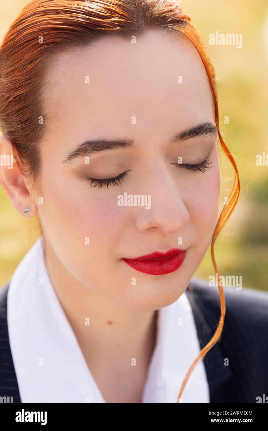 Ein detailreiches Porträt einer Flugbegleiterin, die ihr professionelles Make-up und ihren ausgeglichenen Ausdruck zeigt und die Eleganz der Luftfahrtindustrie widerspiegelt Stockfoto