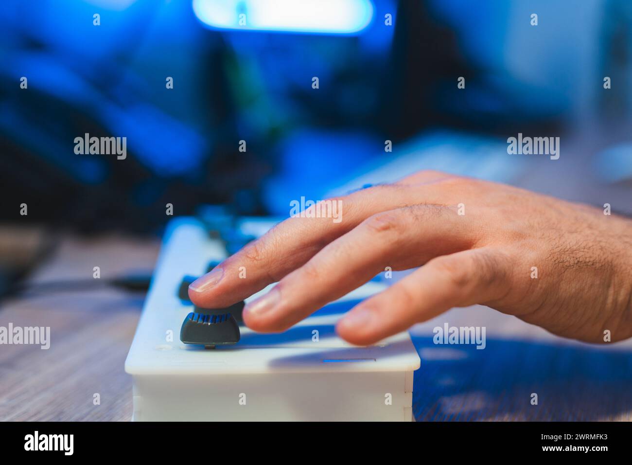Zugeschnittene, nicht erkennbare Hand, die Audiogeräte während einer Tonstudio-Sitzung anpasst. Stockfoto