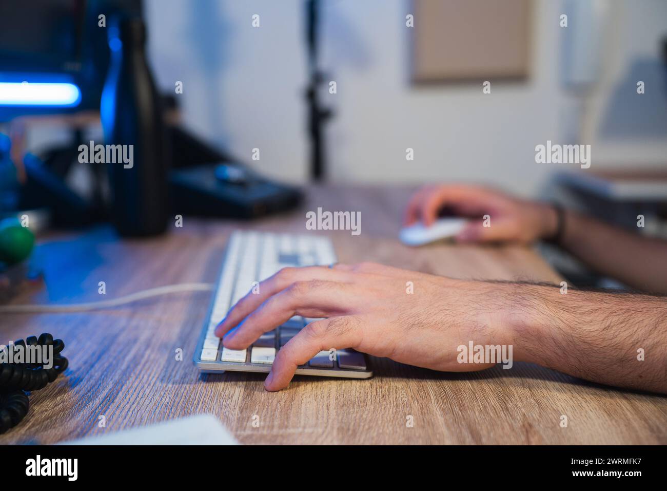 Zugeschnittene, nicht erkennbare Hände des Tontechnikers bearbeiten Audio auf einer Tastatur in einem professionellen Studio-Setting. Stockfoto