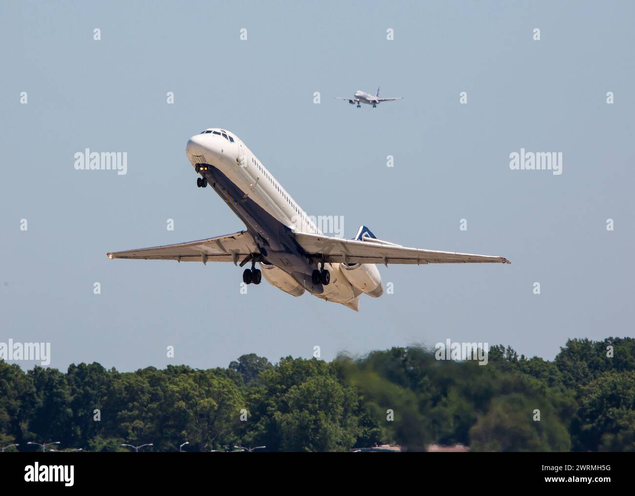 Ein Verkehrsflugzeug zieht aus einer geschäftigen Flughafen als das zweite Flugzeug hinter bereitet zu landen. Stockfoto