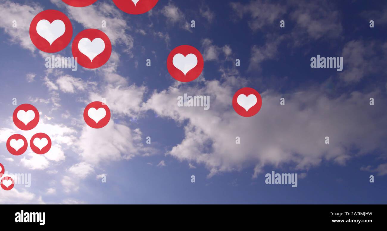 Mehrere rote Herzsymbole schweben gegen einen blauen Himmel mit Wolken Stockfoto