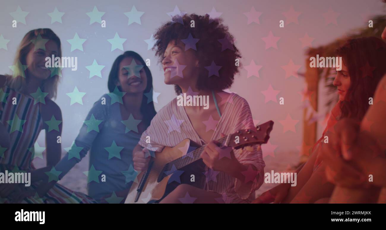 Eine Gruppe von Frauen, die eine Musiksession mit einer Gitarre genießen Stockfoto