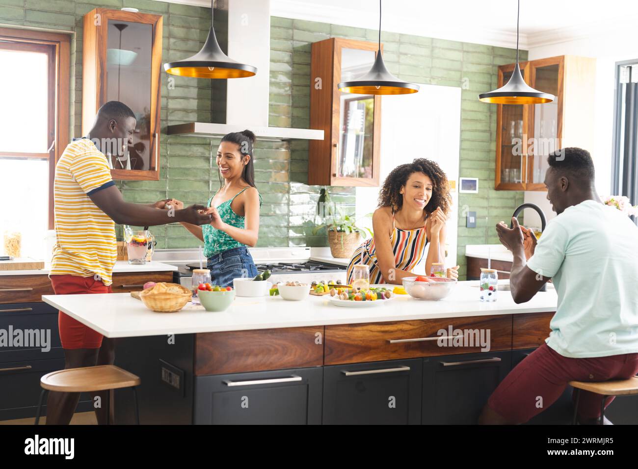 Eine vielfältige Gruppe genießt einen lebhaften Moment in einer modernen Küche Stockfoto