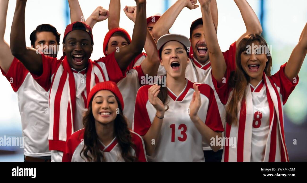 Vorderansicht einer Gruppe von Sportfans in rot-weißen Trikots, die laut jubeln Stockfoto