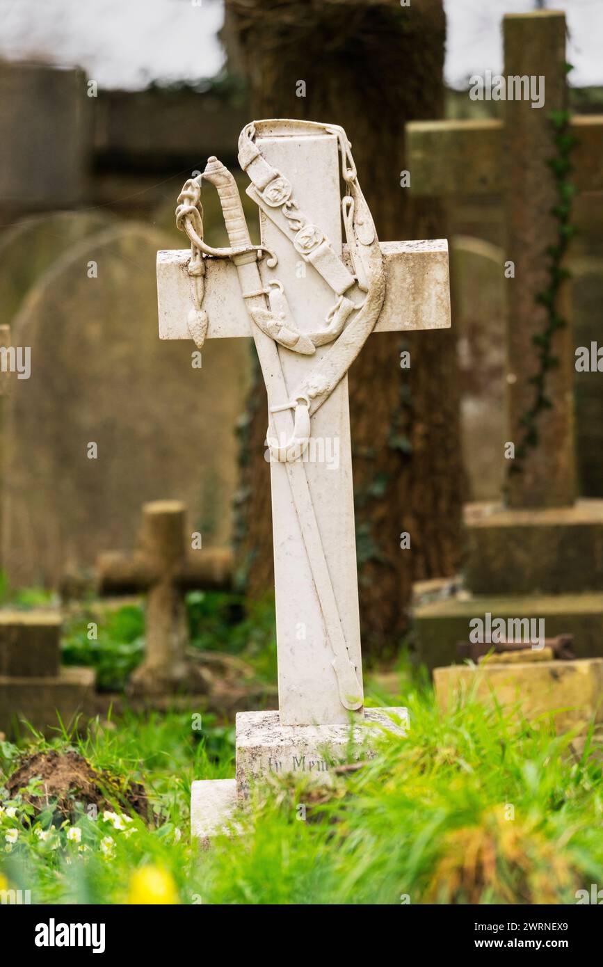 Grabstein in Form eines Kreuzes mit Schwert und Riemen oder einer Baldrik auf dem Grab eines Offiziers der Royal Artillery auf dem Southampton Old Cemetery Stockfoto