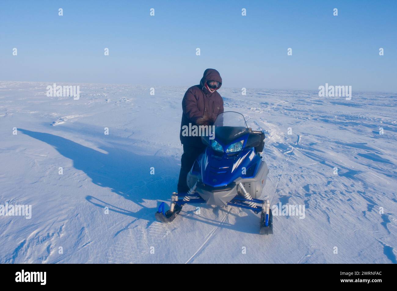 Inupiaq Reiseleiter Frosty, der vor seinem Schneemobil stand, wartete auf die arktische Küste Alaskas Stockfoto