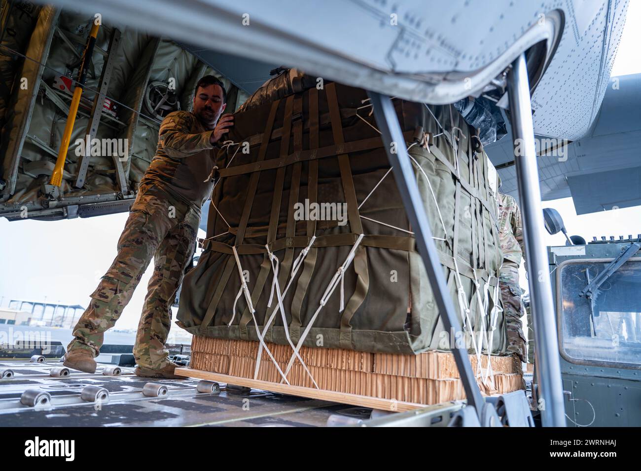 Zarqa, Jordanien. 11. März 2024. Ein Ladungsmeister der US-Luftwaffe platziert Paletten mit humanitärer Hilfe zum Verladen in die Frachtbucht eines C-130J Super Hercules-Flugzeugs der US-Luftwaffe auf der King Abdullah II Air Base am 11. März 2024 in Zarqa, Provinz Zarqa, Jordanien. Die Nahrungsmittelhilfe wird an palästinensische Flüchtlinge abgegeben, die vom israelischen Krieg gegen die Hamas gefangen sind. Foto: A1C Caleb Parker/US Air Force Photo/Alamy Live News Stockfoto