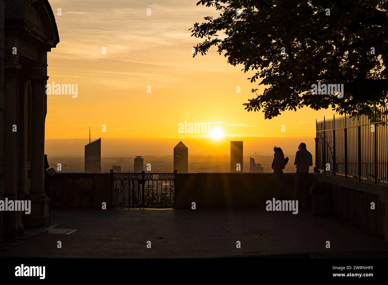 Silhouettes de personnes contemplant le Lever de soleil sur les Tours du quartier d’affaire de la Part-Dieu à Lyon depuis Fourvière Stockfoto