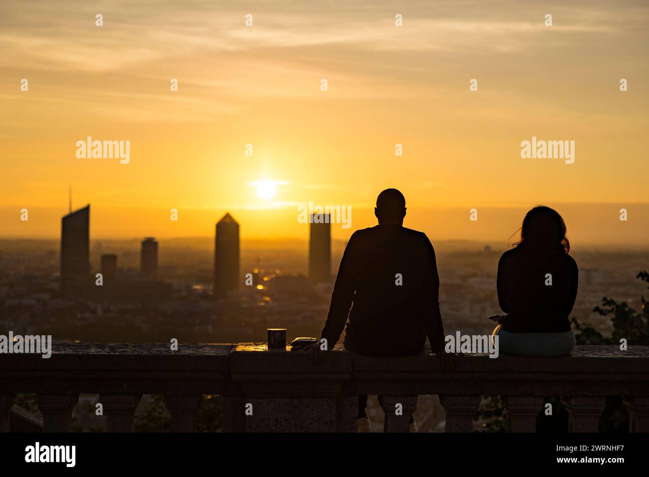 Silhouettes de personnes contemplant le Lever de soleil sur les Tours du quartier d’affaire de la Part-Dieu à Lyon depuis Fourvière Stockfoto