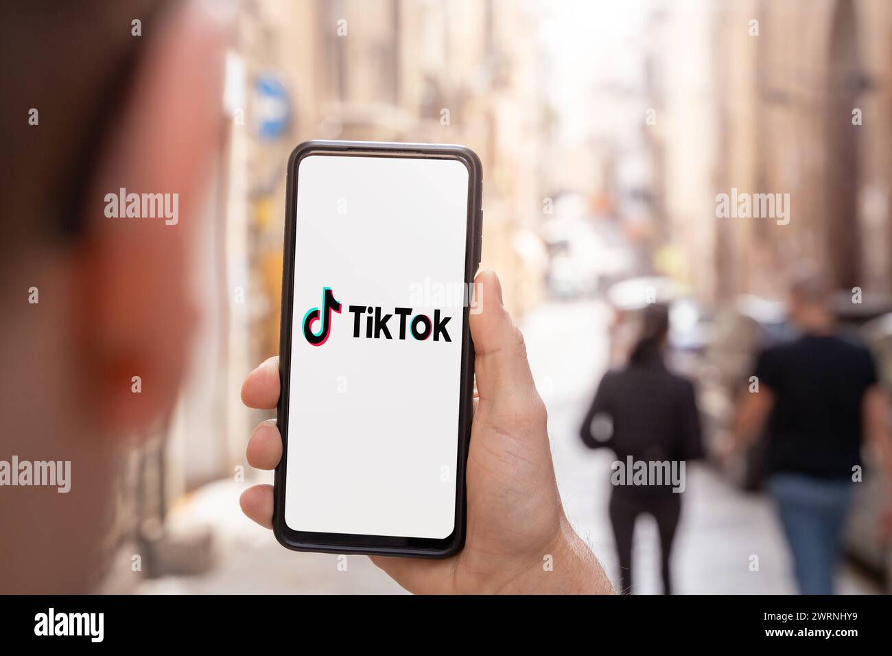 13. März 2024: Mann, der ein Smartphone mit dem TikTok-Logo auf dem Bildschirm hält. FOTOMONTAGE *** Mann hält Smartphone in der Hand mit dem TikTok Logo auf dem Bildschirm. FOTOMONTAGE Stockfoto