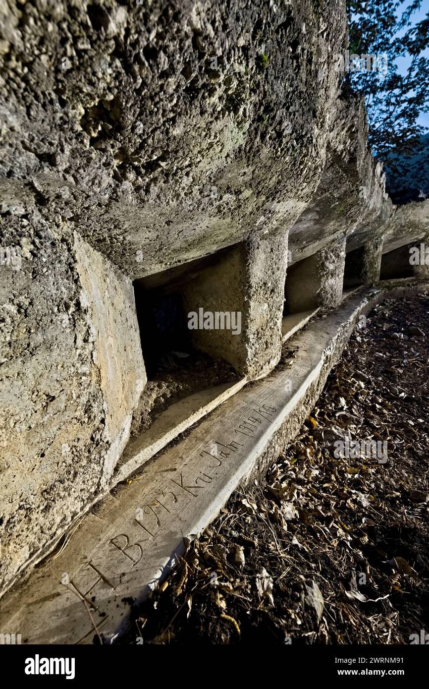 Stahlbetongraben mit Schlupflöchern an der Festung des Großen Krieges auf dem Berg Celva. Unten ist eine Gravur aus dem Jahr 1915. Trient, Italien. Stockfoto