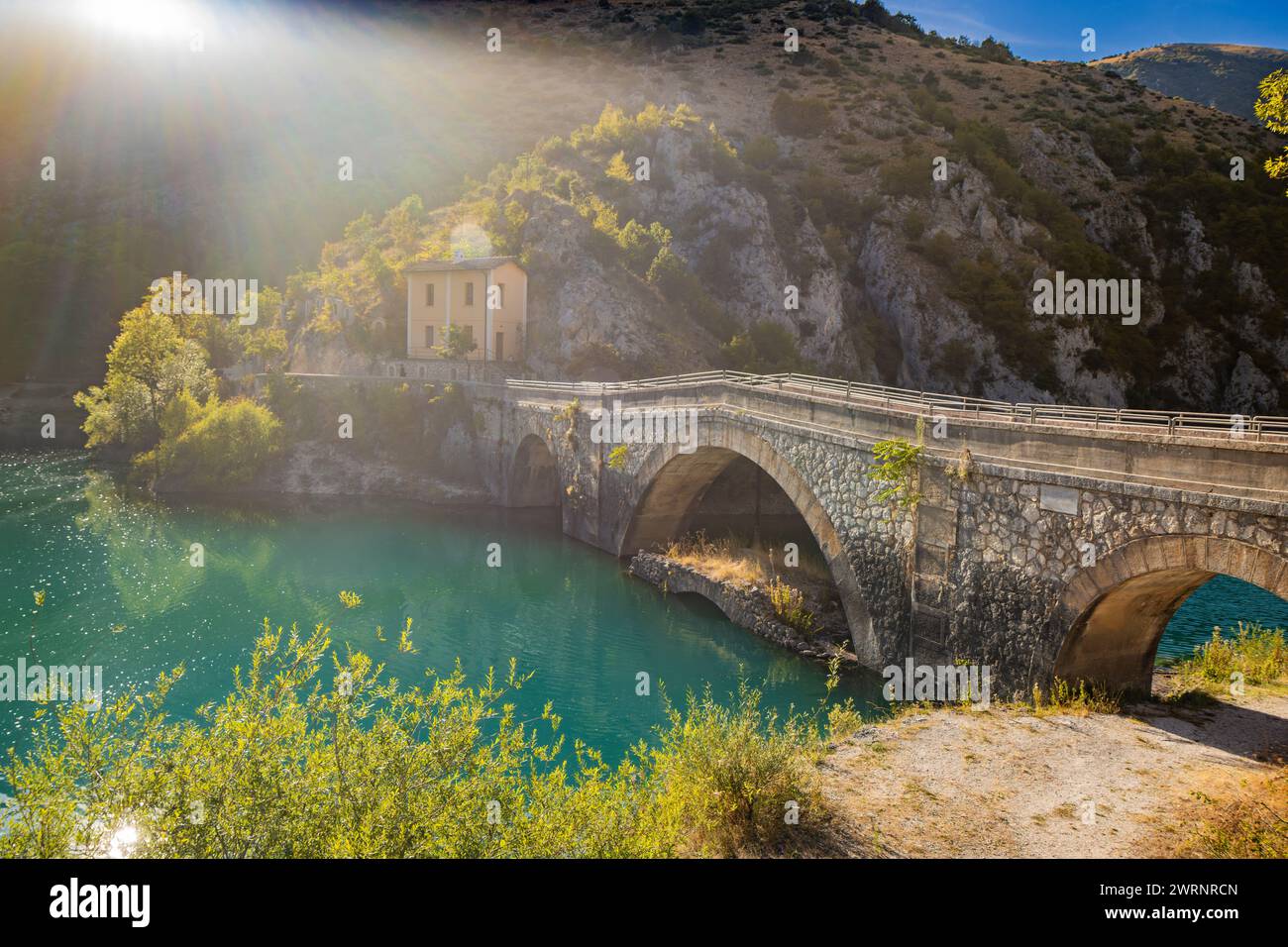 Lake San Domenico, in den Schluchten von Sagittario, in den Abruzzen, L'Aquila, Italien. Die kleine Eremitage mit der Steinbrücke. Die türkisfarbene Farbe des Wassers. Stockfoto