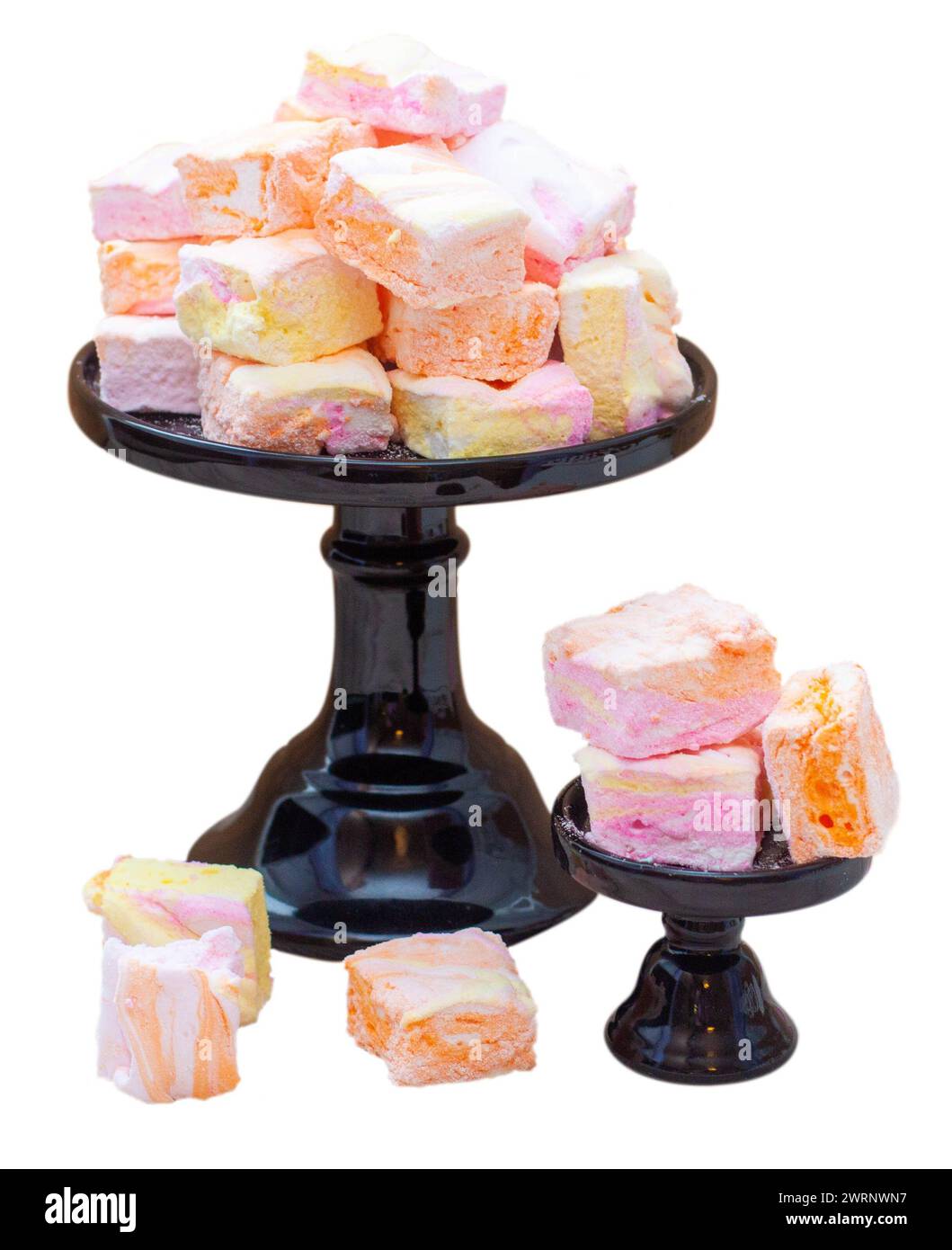 Farbenfrohe, rosa, orange und gelbe hausgemachte Marshmallows aus Eiweiß und Zucker auf einem schwarzen Kuchenständer Stockfoto